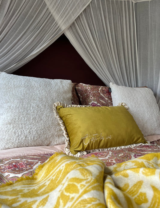 Bed with decorative pillows and a canopy in a bedroom setting